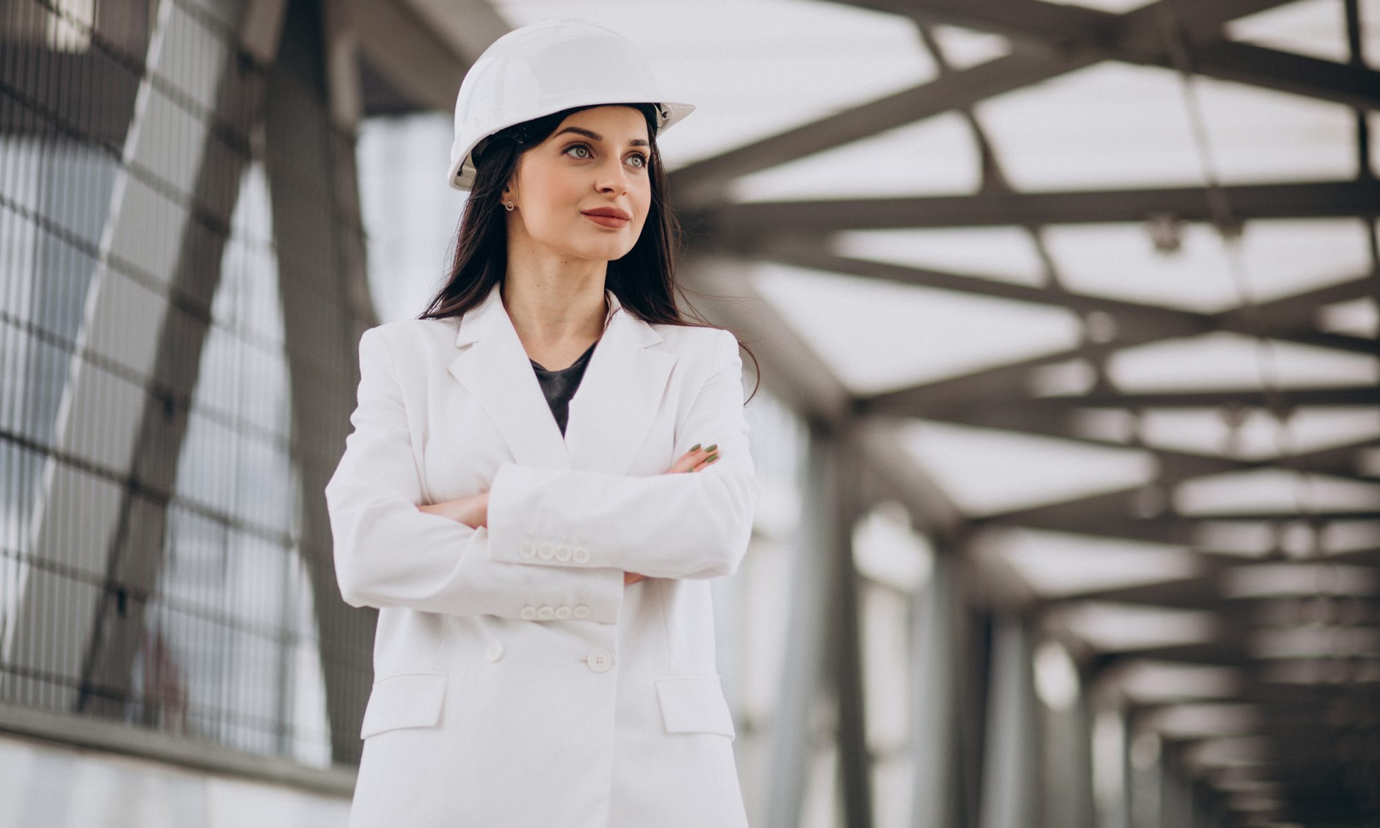 Young business woman wearing hard hat at building object